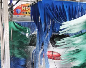 Vehicle inside of automatic car wash tunnel at Speedy Sparkle Car Wash.